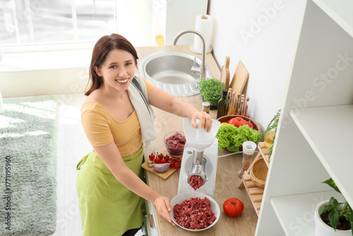 Young housewife using meat ...