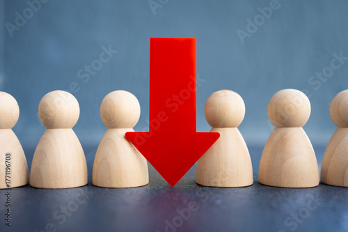 Fotografia Wooden human figures with a large red down arrow represent job loss, downsizing, unemployment, layoffs, resignation, staff reduction, economic crisis, and workforce impact in business concept