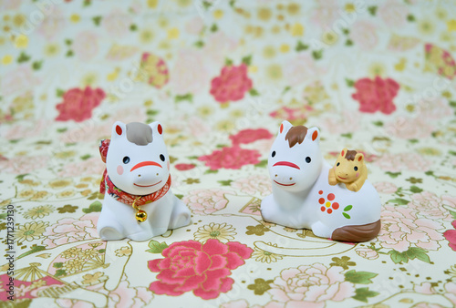 可愛い馬の置物と和柄の背景の年賀状素材