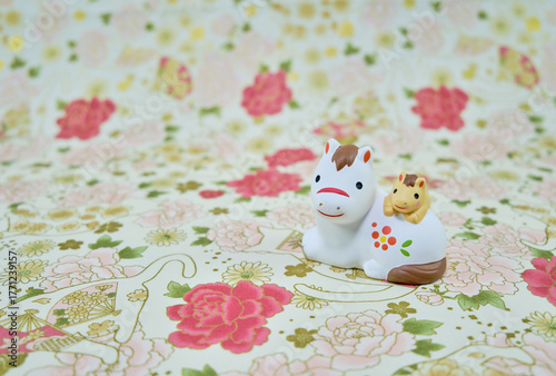 可愛い馬の置物と和柄の背景の年賀状素材