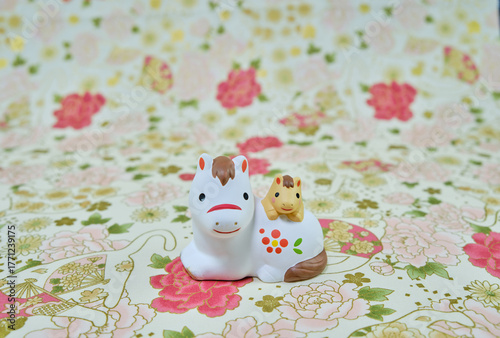 可愛い馬の置物と和柄の背景の年賀状素材