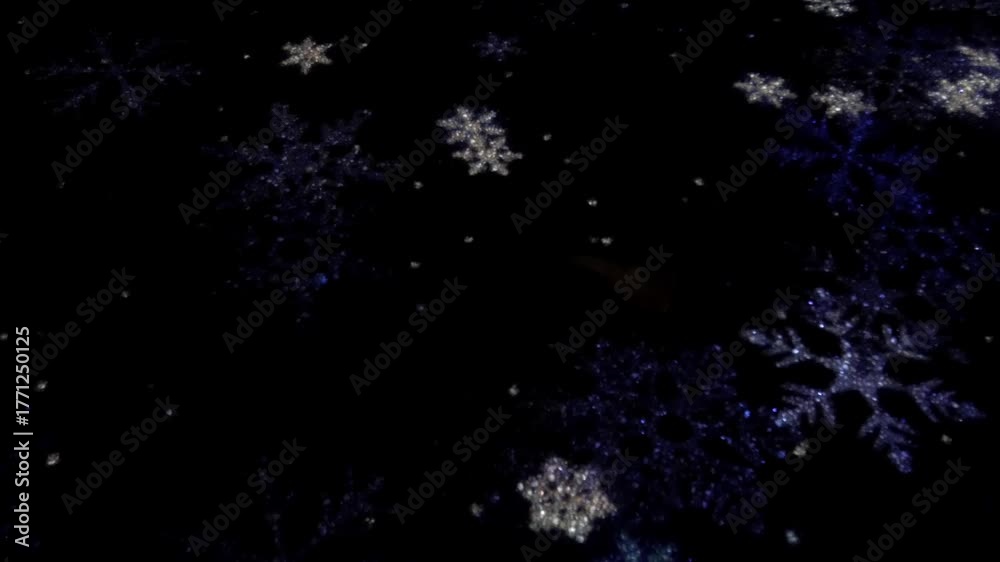 Sparkling snowflakes twinkle on a dark background, creating a festive mood