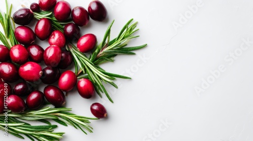Festive arrangement of vibrant red cranberries and aromatic rosemary sprigs for holiday decor with copy space on white background