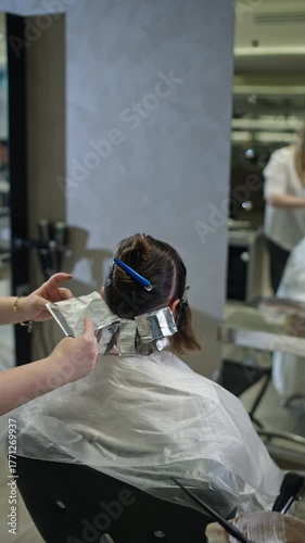 Professional hairdresser coloring woman hair with brush and foil creating beautiful hairstyle salon beauty treatment healthy hair care and modern fashion style
