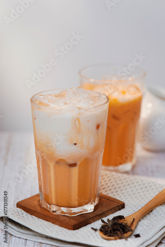 Thai tea with milk in a glass jar placed on a wooden table