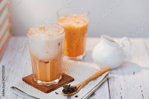 Thai tea with milk in a glass jar placed on a wooden table