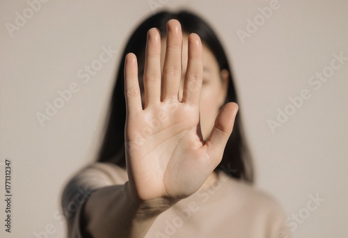 A woman standing with her hand open facing the camera, stop sign with hand, no measn no