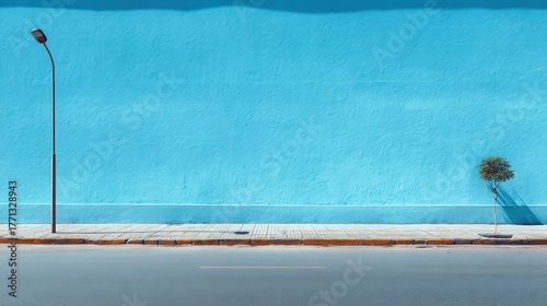 Fototapeta Naklejka Na Ścianę i Meble -  A lone street lamp and a small tree against a vibrant blue wall
