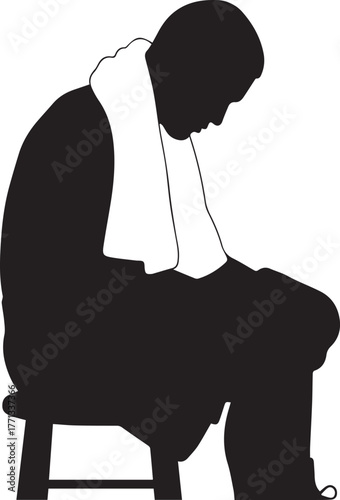 Silhouette of a tired boxer sitting on a stool wearing a towel after training