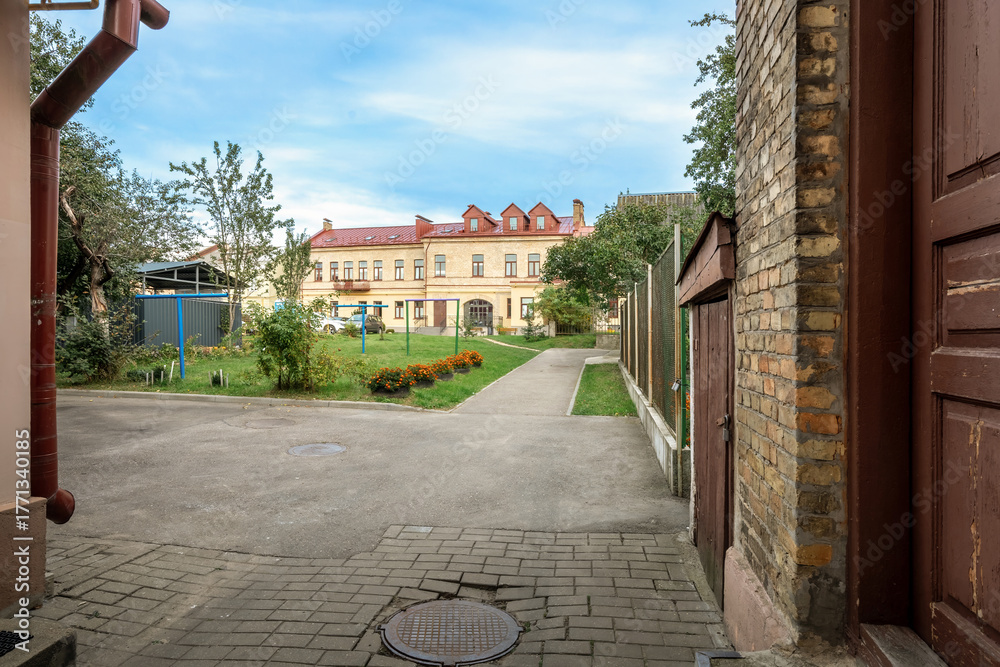 Fototapeta premium Old courtyard with paved walkway leading to historic residential building