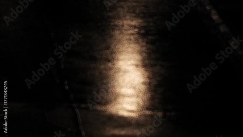 Blurry, abstract footage of rain fall on city street asphalt at night. Close up, telephoto footage, top down, real time, catadioptric donut shaped bokeh, no people