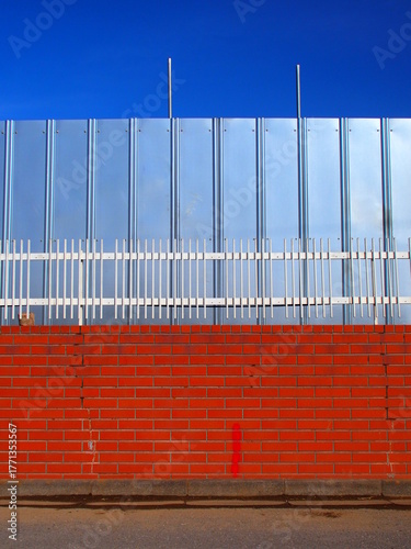 煉瓦塀と解体工事現場のフェンス