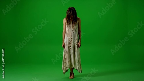 Eerie Young Woman in Tattered Dress Stands Barefoot on Green Screen Background