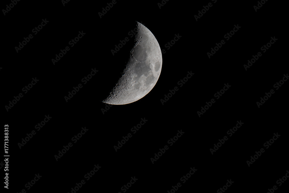 Naklejka premium Close-up view of the Moon in night sky showing visible craters and surface details. Astronomical photograph of lunar phase.