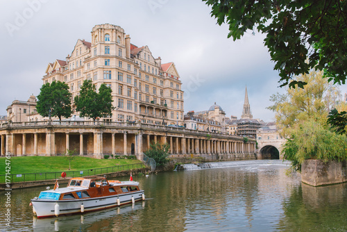 Parade Gardens and The Empire Hotel with Bath Abbey in background seen across the River Avon in Bath, UK.
