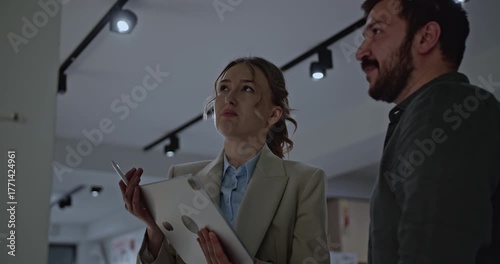 Young professionals collaborate on a project using a tablet in an office setting. They discuss ideas and strategies for business success.