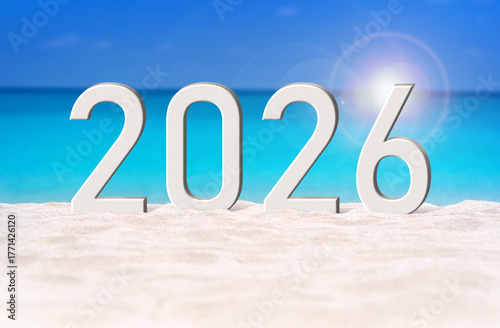 Happy New Year 2026, lettering on white sand beach with clear blue sea background. Numbers 2026 year on sand dunes at the sea shore, celebrating new year concept, copy space.