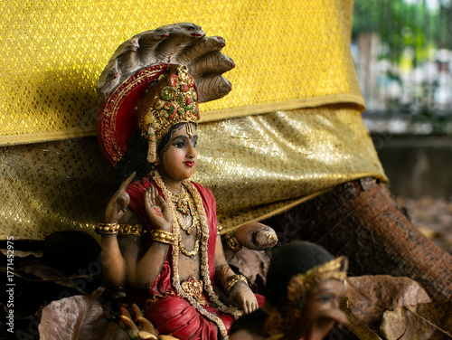 Konstfotografi Hindu God Vishnu Statue in Red Robes with Golden Crown and Ornate Jewelry Sittin