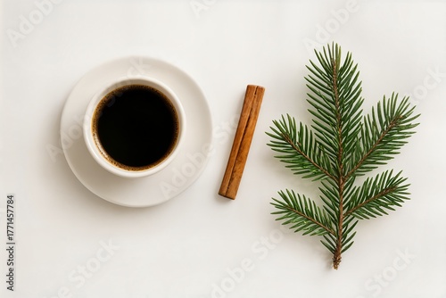 Minimalist winter flat lay with cup of coffee, cinnamon stick and fir branch on white background, cozy morning Christmas mood