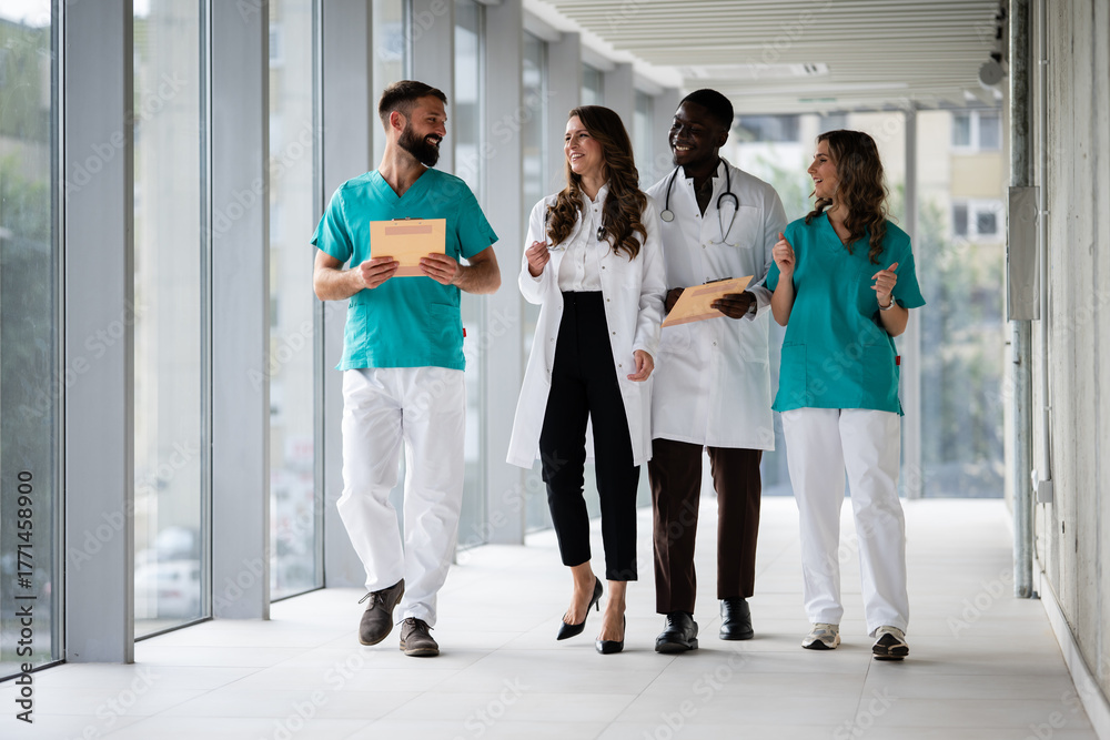 Fototapeta premium Diverse medical team walking and smiling in hospital corridor