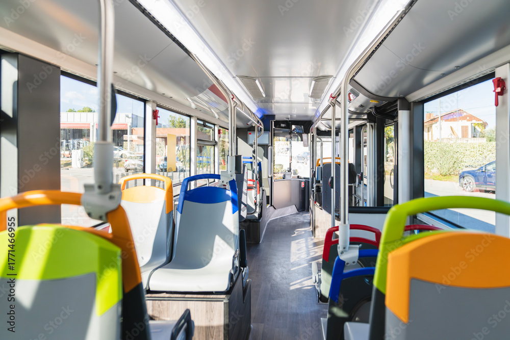 Fototapeta premium Bus interior with rows of empty seats and grab handles, showcasing modern public transportation and urban commuting space