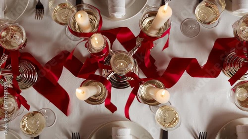 Elegant table setting with red ribbons and candles for a festive celebration