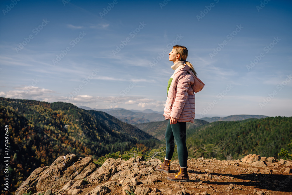 Fototapeta premium Woman enjoying fresh air on mountain peak