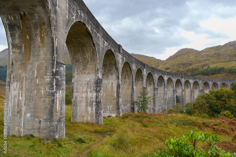 Obraz premium Glenfinnan viaduct curving through scottish highlands landscape