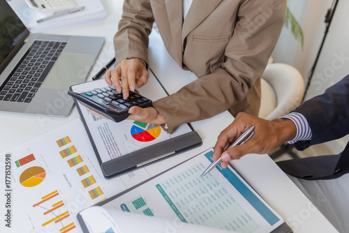 A group of business professionals engaged in a serious office discussion, analyzing financial reports and exchanging ideas to solve problems and make effective corporate decisions.