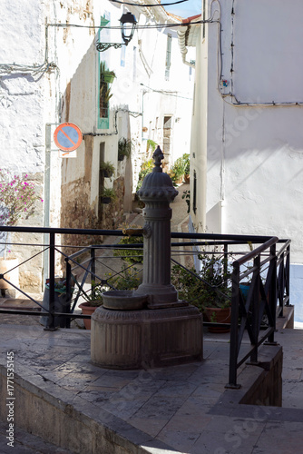 an old water pump on the street, next to houses