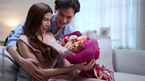 Handsome Asian man gives his girlfriend flowers on a special day.
