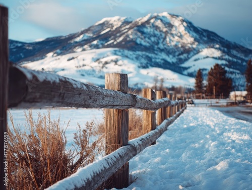 Golden Hour Glow: Snow-Dusted Wooden Fence with Blurry Mountain Background at Sunset