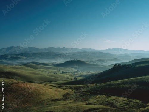Expansive Green Rolling Hills Foggy Valley Mountains Morning Haze Calm Blue Sky Rural Countryside Tranquil Landscape Serene Nature View Wide Open Spaces Outdoor Scenery Sunrise Light