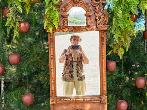 Mature blonde woman enjoying a travel excursion while taking a selfie in a scenic outdoor setting