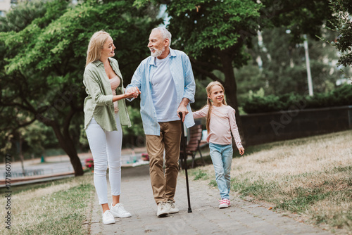 funny heartwarming stroll in the park with grandpa daughter and little girl sharing smiles and love
