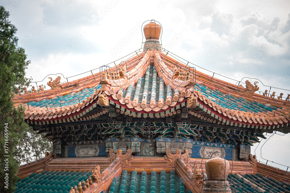 Naklejka premium Ancient building details from Beijing, China's Summer Palace. Close up view showcasing architectural designs. Ornate structure under a cloudy sky.