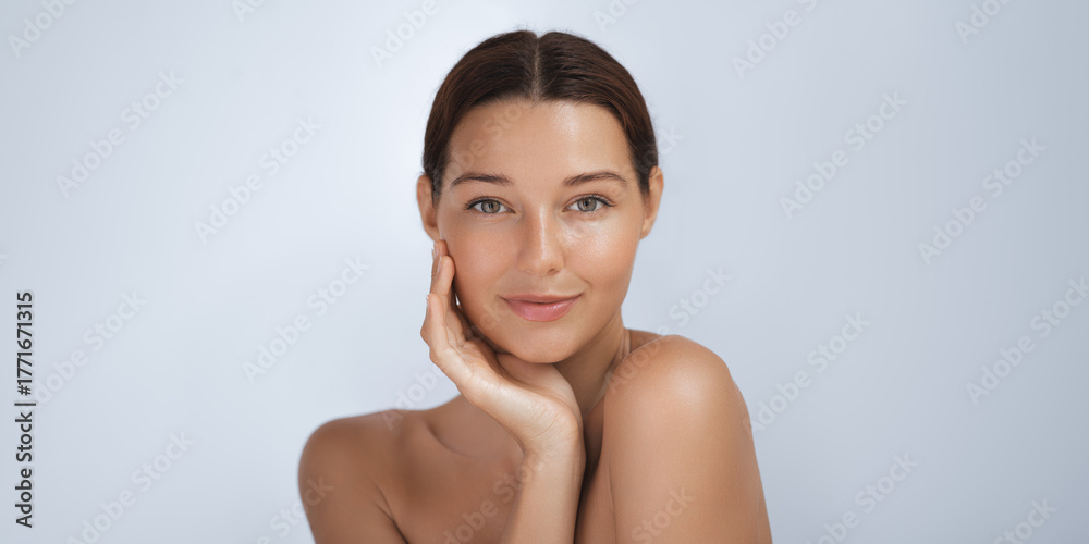 Obraz premium Beautiful Woman With Radiant Skin Touching Her Face Gently