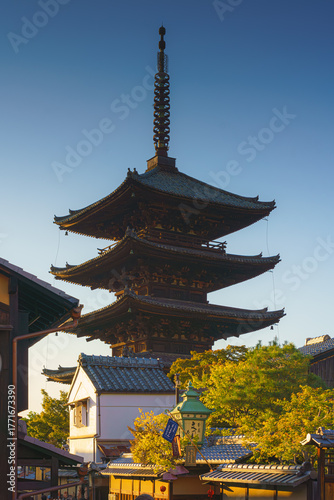 Kyoto, Japan - Oct 11 2024, vertical view of Yasaka Pagoda of Hōkan-ji Temple, building facades and trees in the foreground, without people, in the evening, Kyoto, Japan