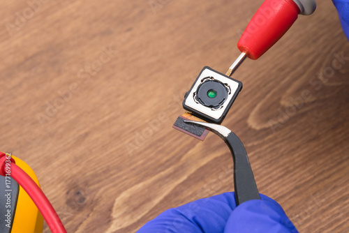 Using tweezers for repair and voltage measuring device for phone display parts