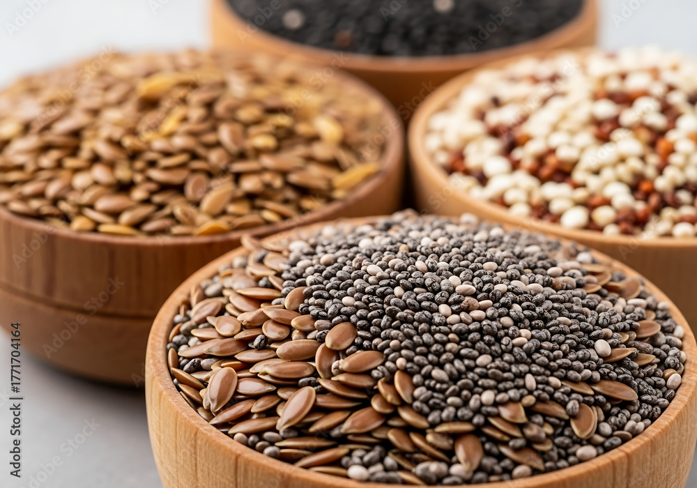Obraz premium Close-up macro photo of assorted organic superfood seeds in small wooden bowls, realistic natural light