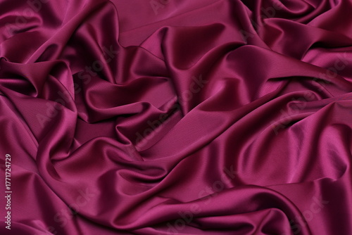 Photography Horizontal close-up of luxurious fuchsia pink acetate satin fabric, heavily draped and folded to showcase its silky texture, rich luster and flowing nature