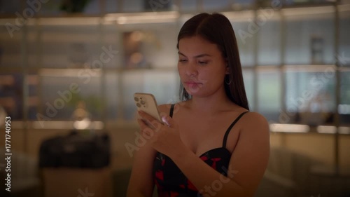 woman relaxing online, woman is peacefully browsing her phone in relaxed manner on her sofa at home