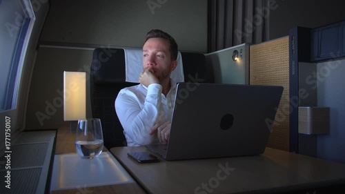 A professional expert in the luxury air travel sector is working diligently on a laptop device
