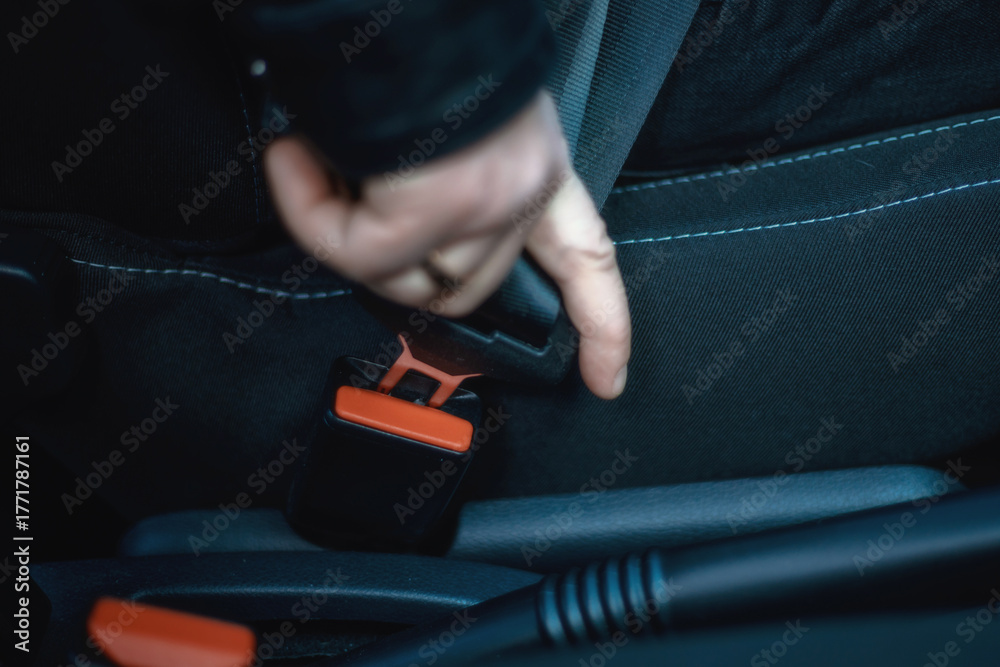 Ταπετσαρία A close-up of a person's hand inserting a seat belt tongue