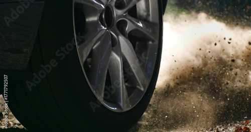 Slow Motion lose-up of a car wheel spinning and kicking up dust on a dirt road. Dynamic slow-motion footage capturing power and movement a1000 fps.
