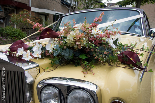 Elegant Vintage Cream Wedding Car With Floral Arrangement Of Hydrangea Orchids And Ivy
