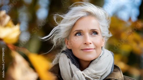 Woman enjoying autumn in a park with colorful leaves and a bright blue sky