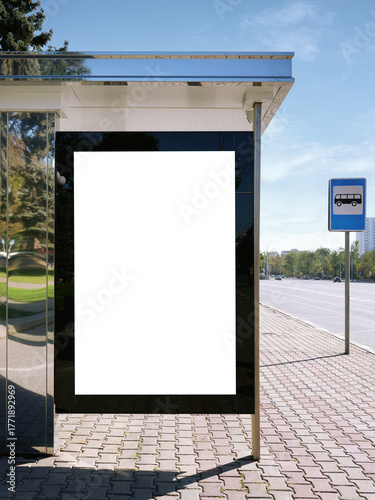 A bus stop against a beautiful sky in a modern city with empty advertising banners inside.
