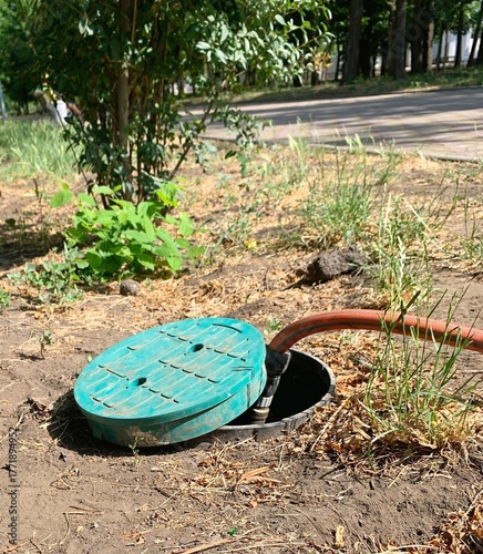 A hose connection point to the water supply in a city park.