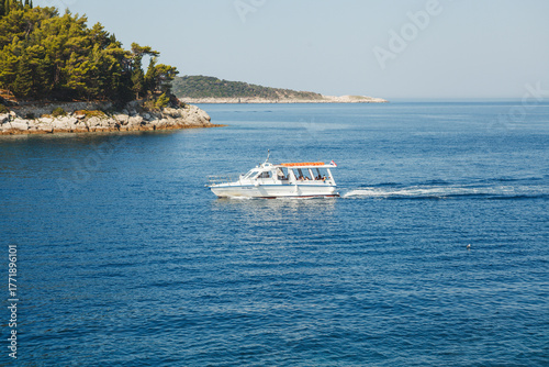 A beautiful yacht sails through calm waters surrounded by beautiful nature.